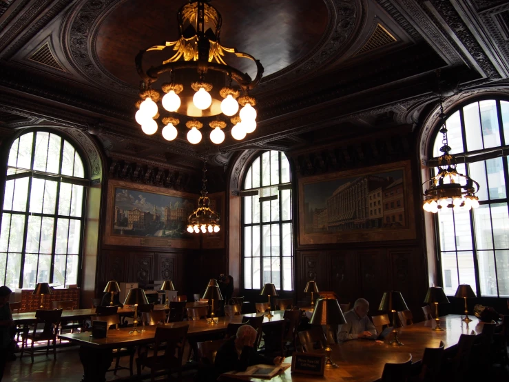 several windows a chandelier and a table with chairs