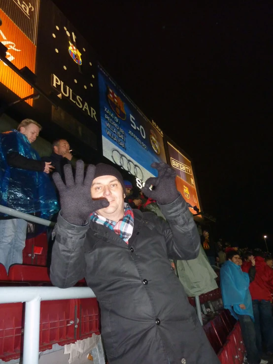 a man poses for a po at anfield