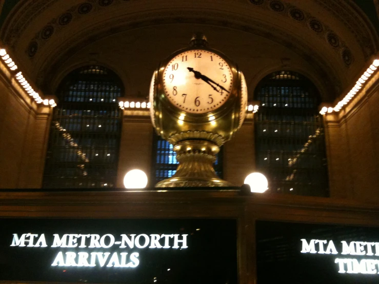 a large clock in the middle of a train station