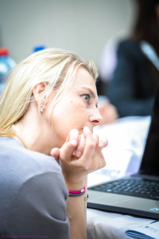 a woman with her hands to her chin