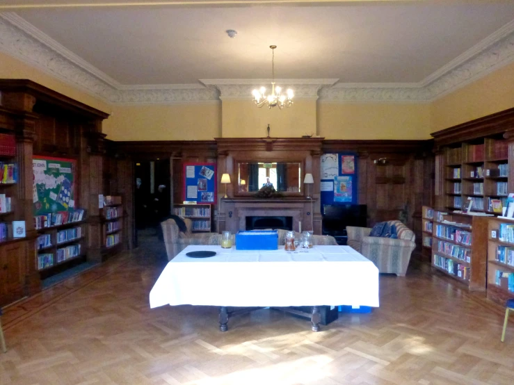 an empty table in a liry with chairs and books on shelves