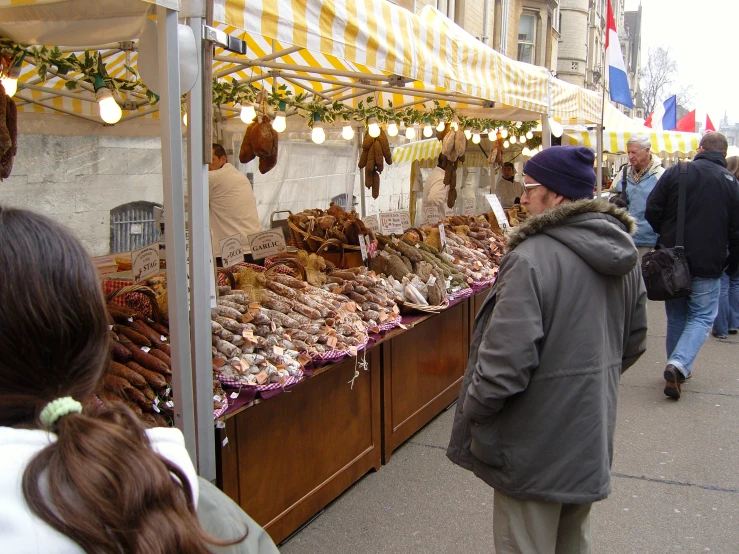 a number of people at a stand near a street