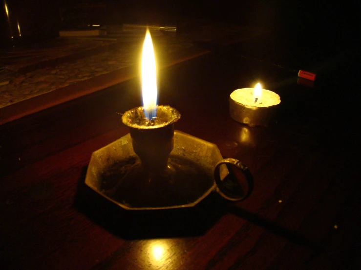 a candle sitting in a bowl with a lighter