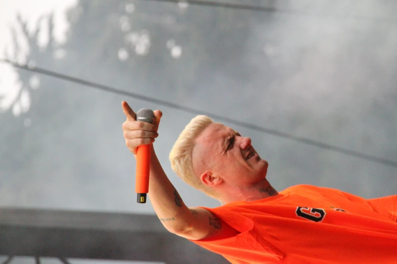 a man with blond hair holding a microphone
