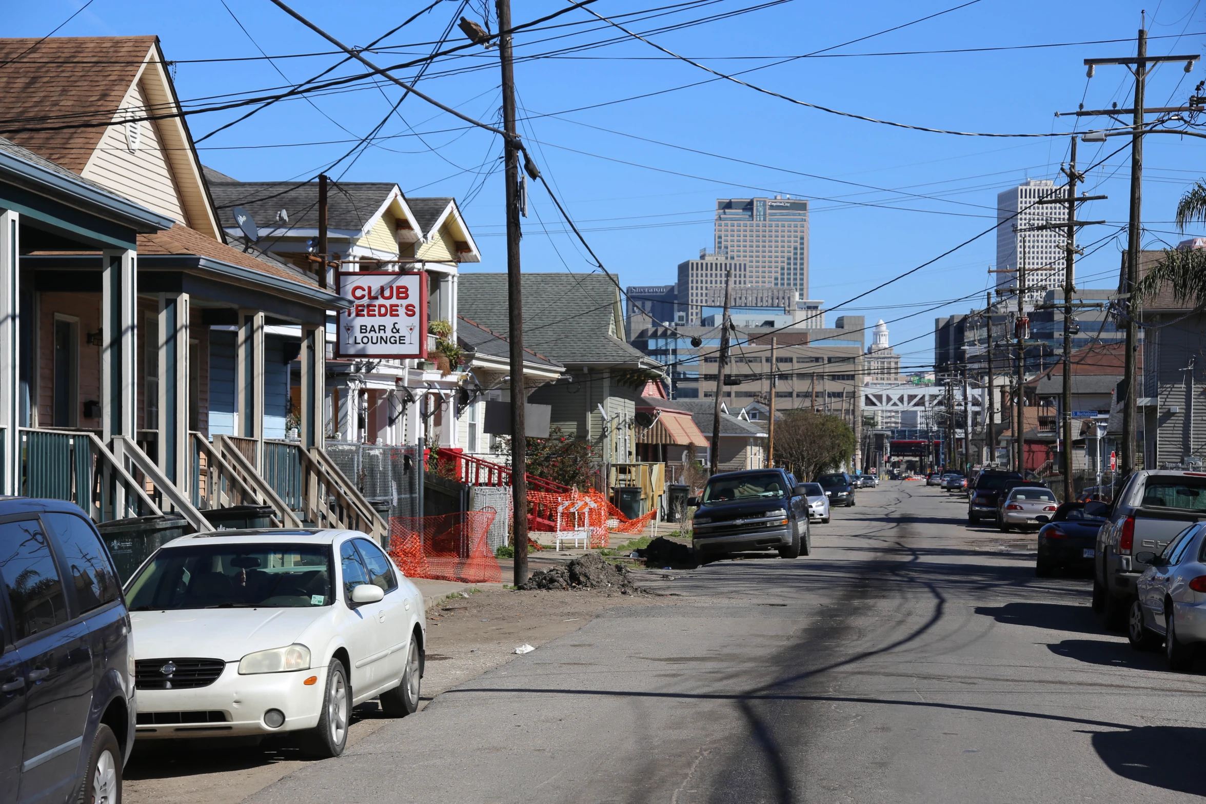 street with several parked cars in front and houses on the other side