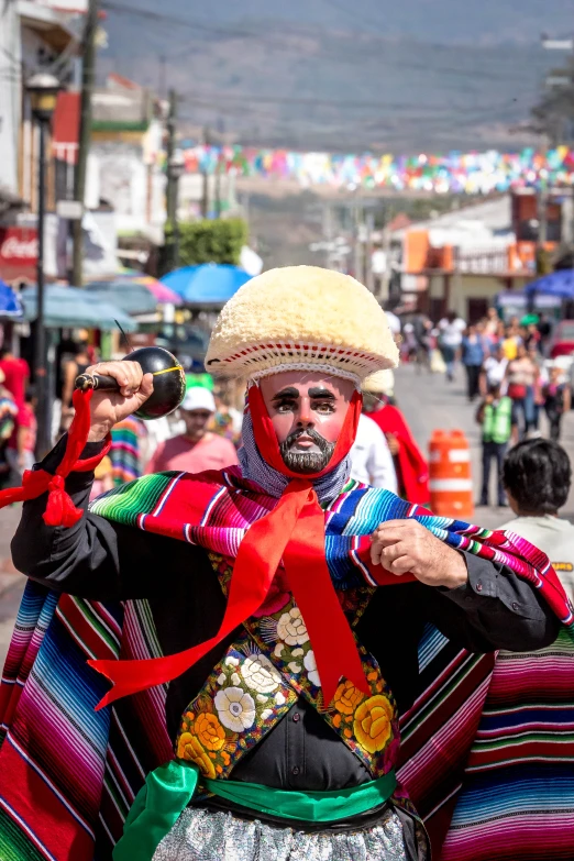 the man has been dressed as a colorful native dancer