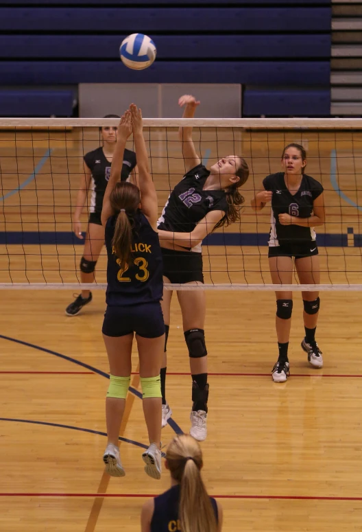 the women are playing volleyball on a court