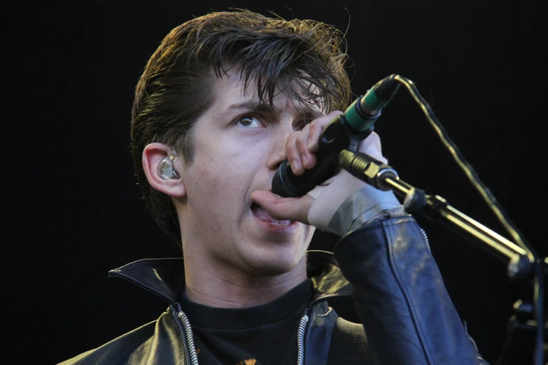a male singer with headphones on singing into a microphone
