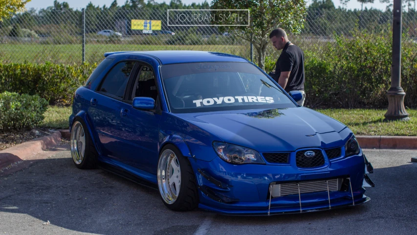 a blue subaruged subarued subaruzed car parked in a parking lot