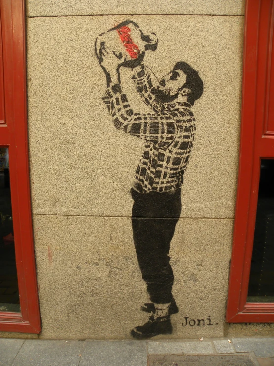 graffiti art of a man holding a tennis racket, on the side of a building