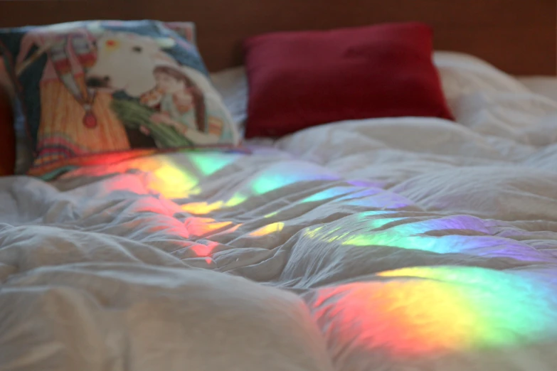 a close - up of a rainbow dyed blanket on a bed