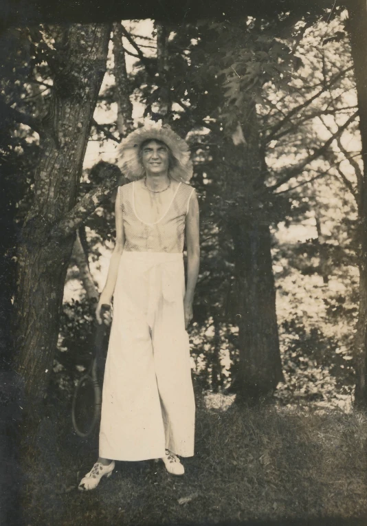 a black and white po of a woman standing next to trees