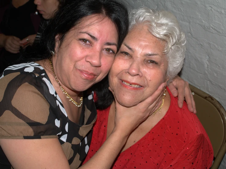 two women hugging each other while sitting down