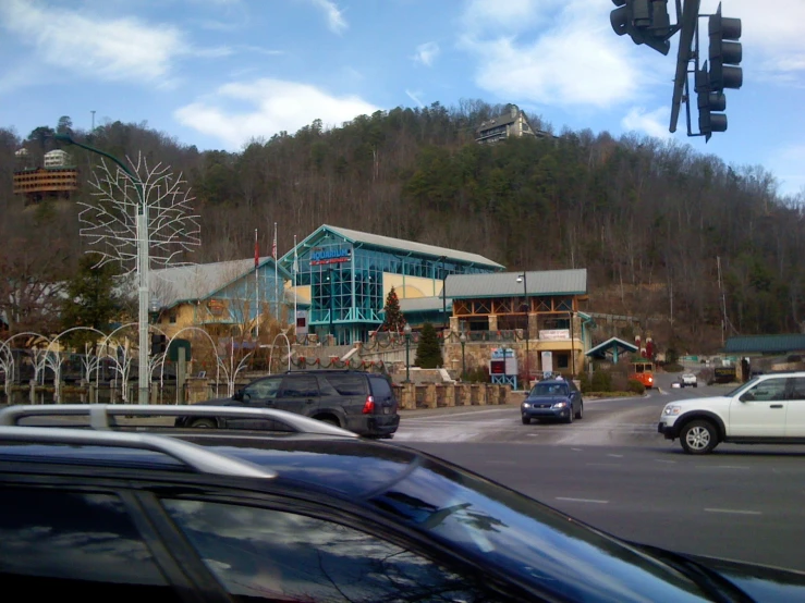 a parking lot with a green building and cars on it