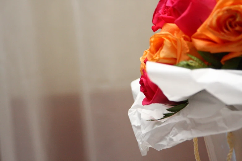 the colorful roses are tied in ribbons