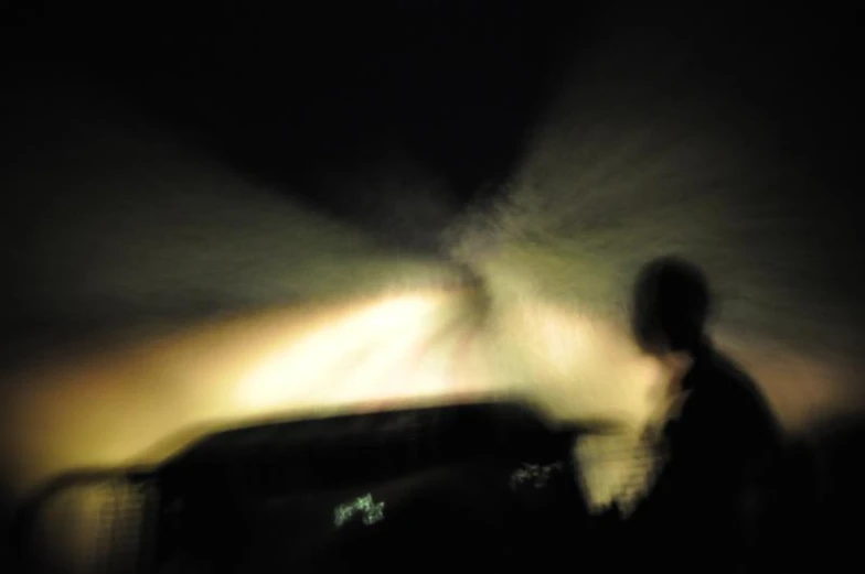 blurry image of the top of a man's head in dark lighting