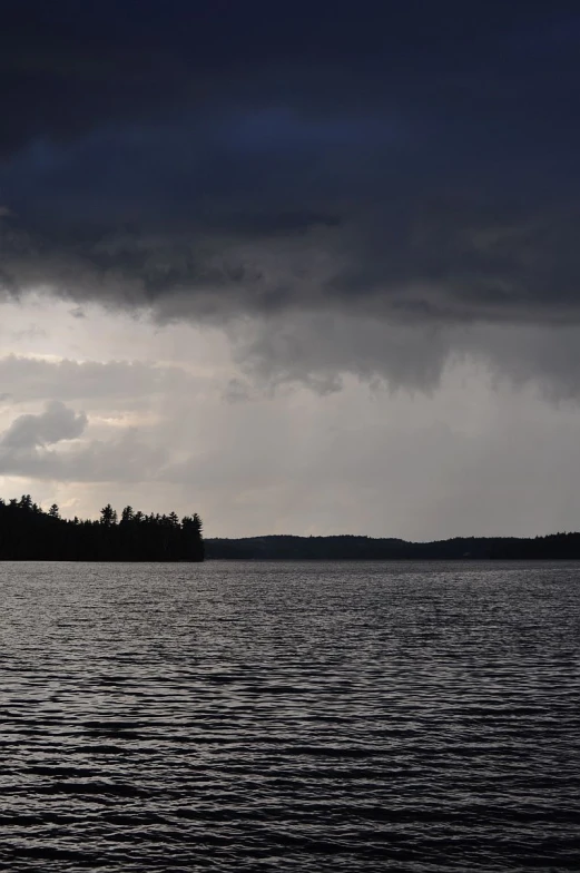 some dark clouds are over some water