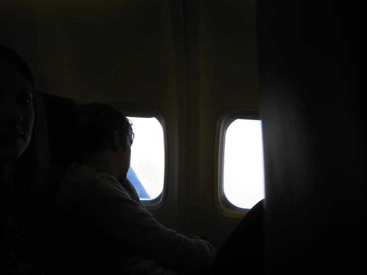 a person is sitting on a plane looking out of the window