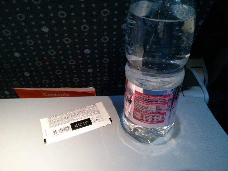 a water bottle sitting on the counter, next to an empty ticket