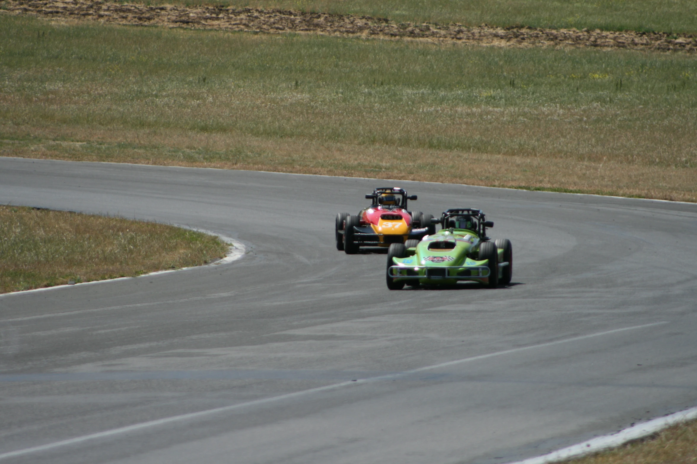 two people on some sort of racing cars on the track