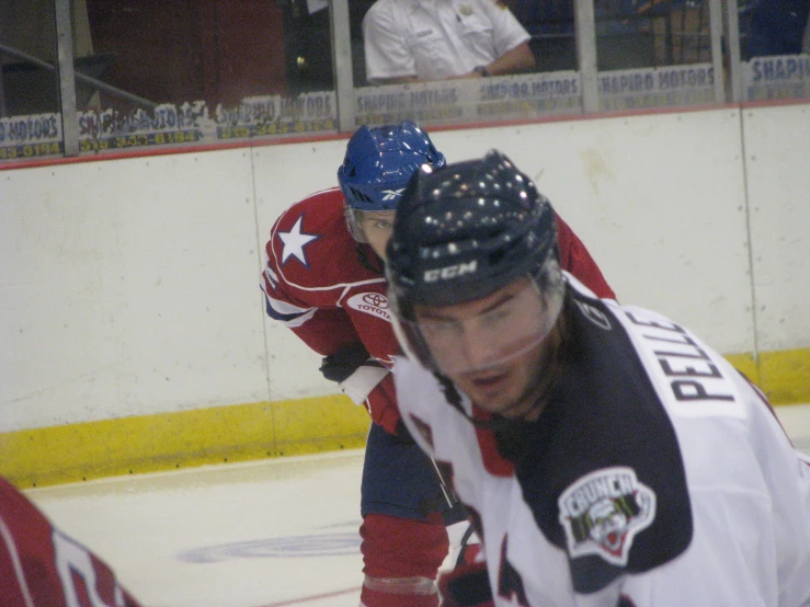 two hockey players, one looking down while the other looks