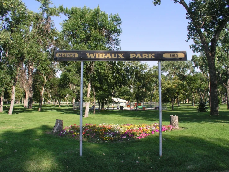 a sign near a park in a green field