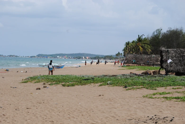 a group of people standing on top of a sandy beach