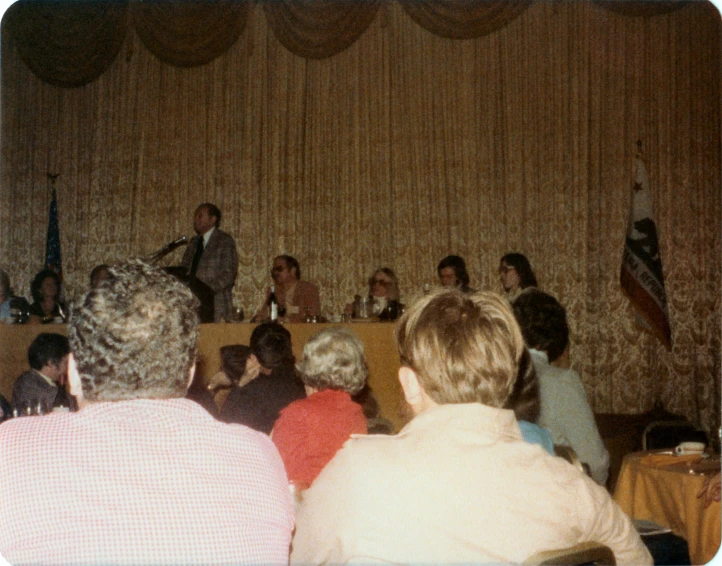 several people sitting at tables during a political debate