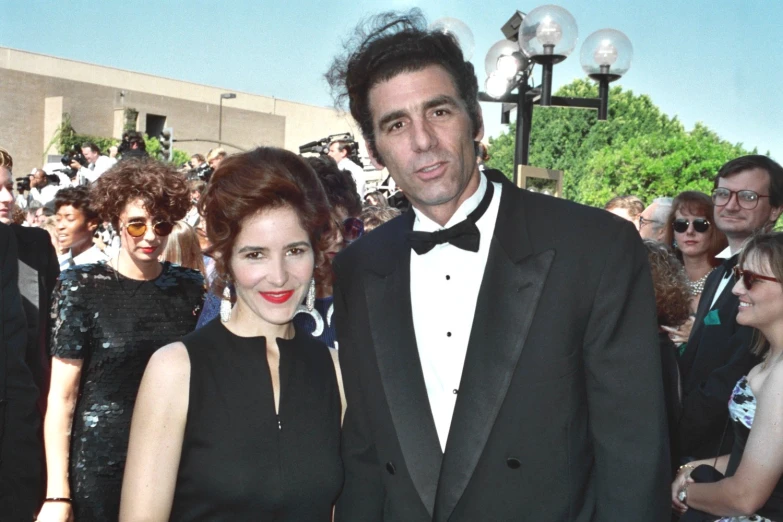 a man in a tuxedo and woman standing together
