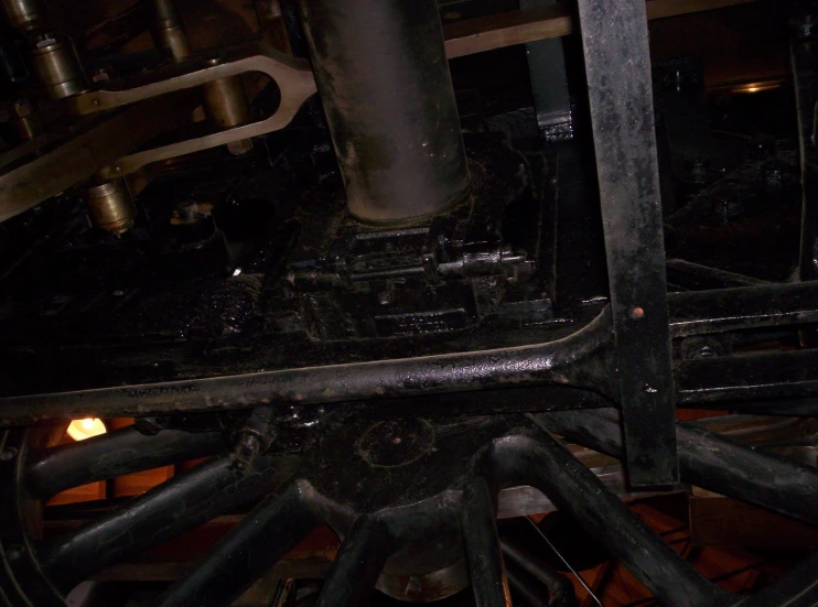 the engine of an antique train as seen through a metal frame