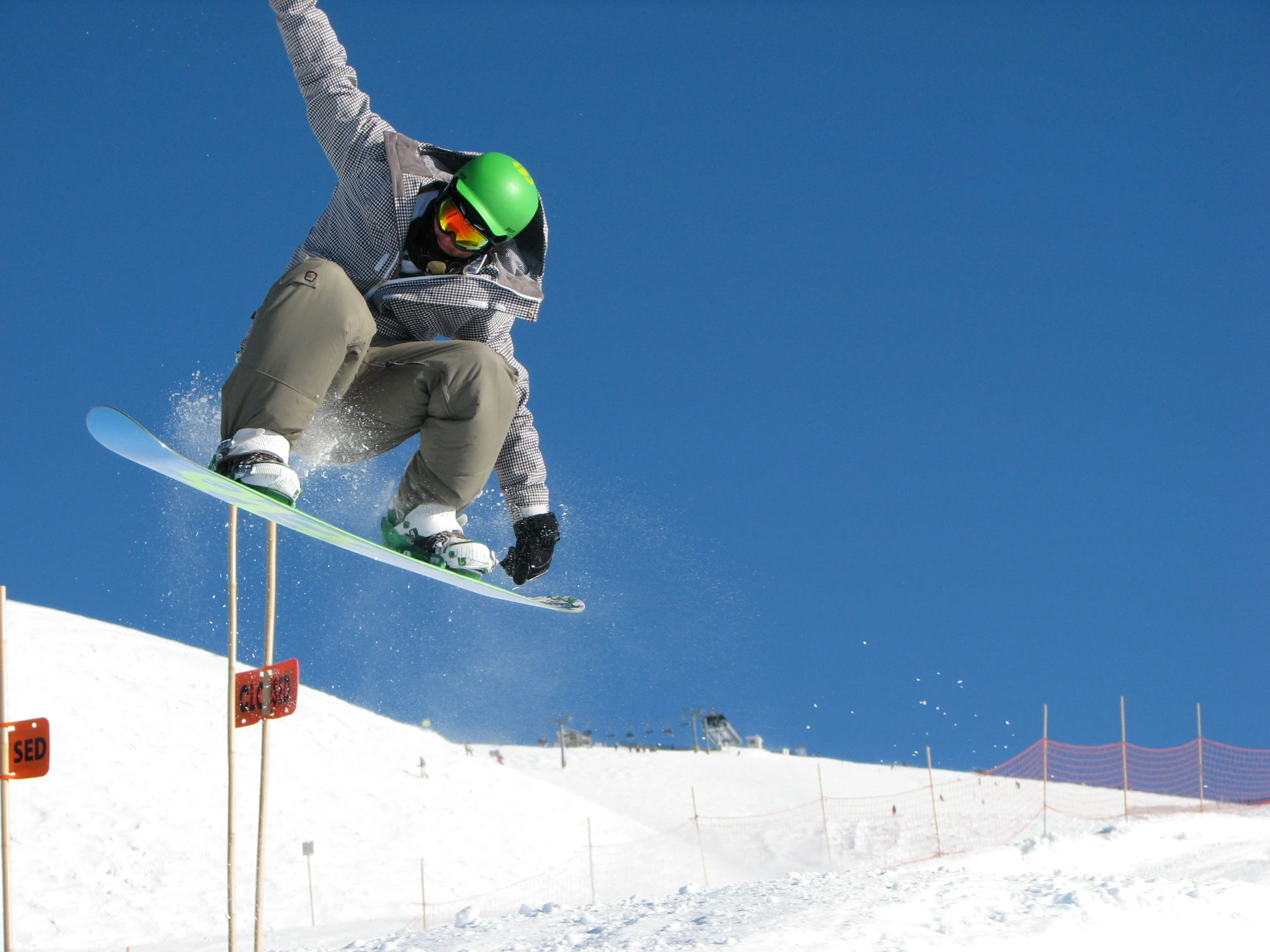 a snow boarder in a helmet is doing a trick