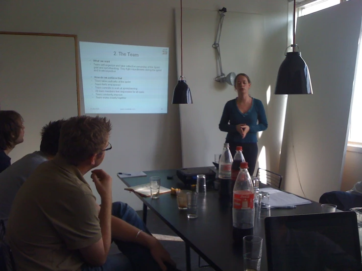 a woman at the front of a room with people