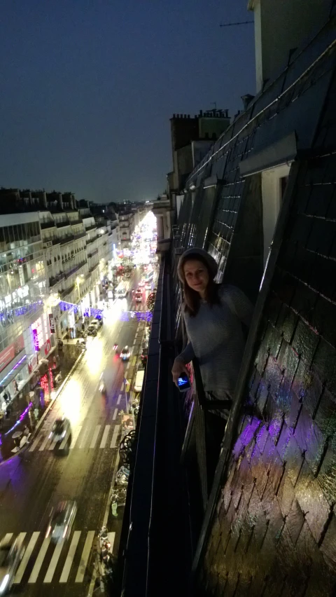 woman standing on top of the stairs in a balcony at night