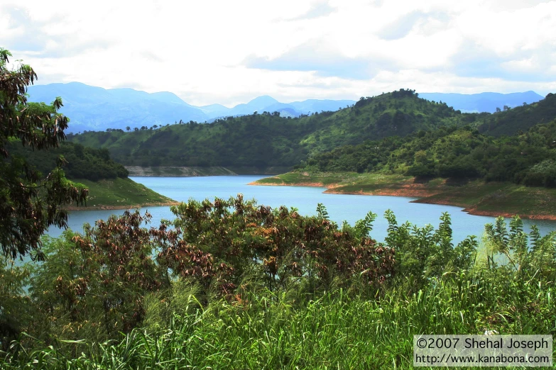 a river is in front of a grassy hillside