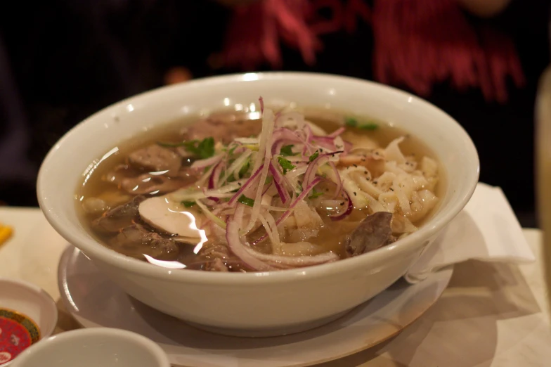 a bowl of stew with a spoon and a piece of bread