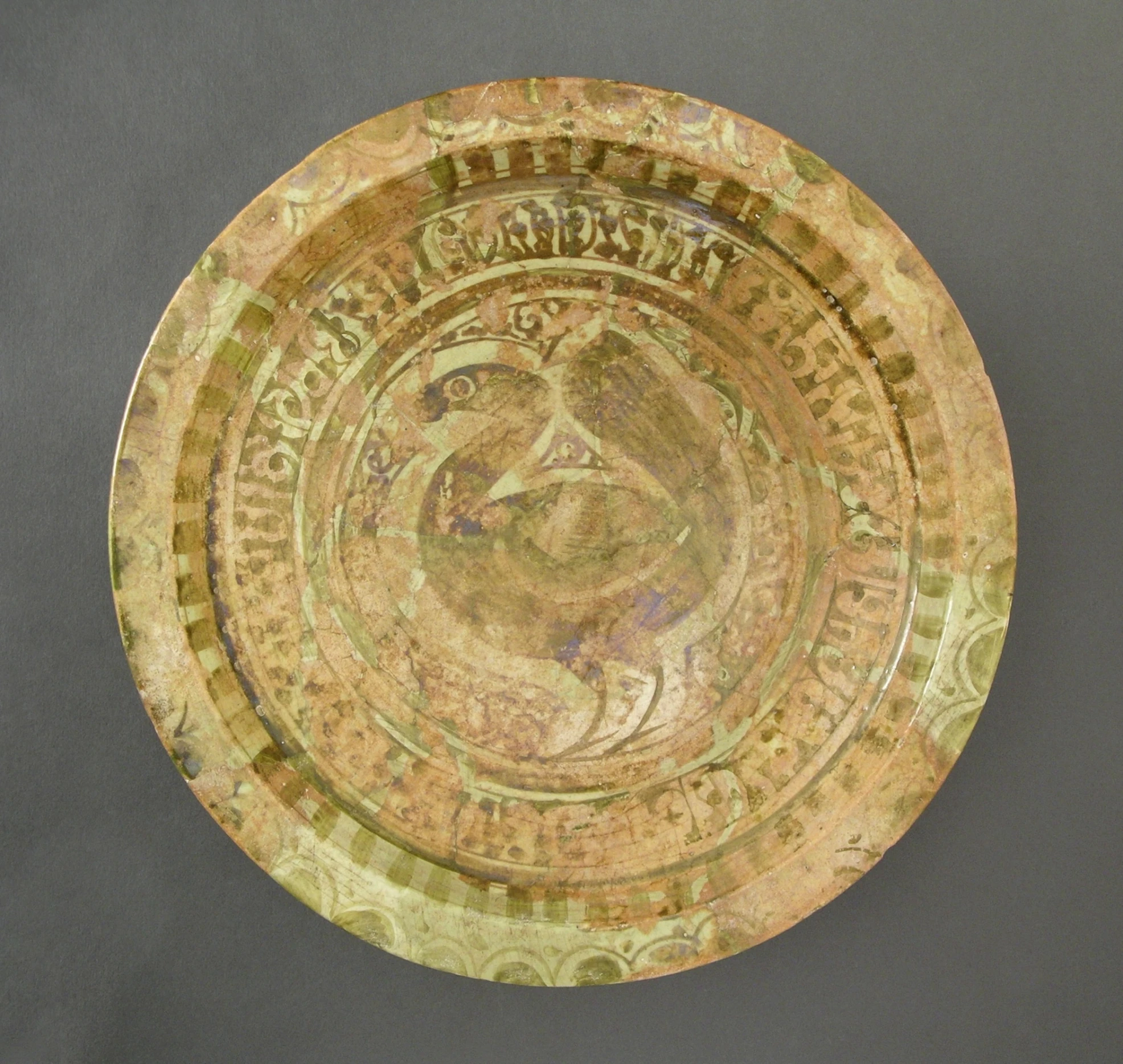 an ornate glass plate with gold leaf designs on a gray background