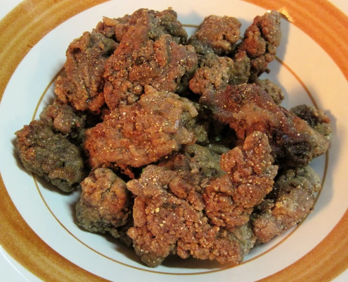 a white bowl filled with meat sitting on a table