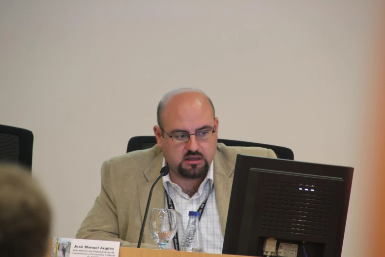 a man with a beard sitting in front of a computer