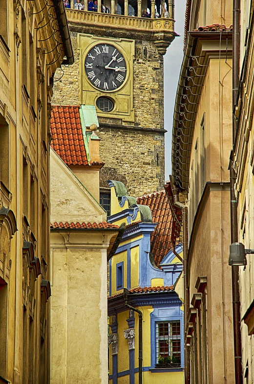 an old town alley with a clock tower in the distance