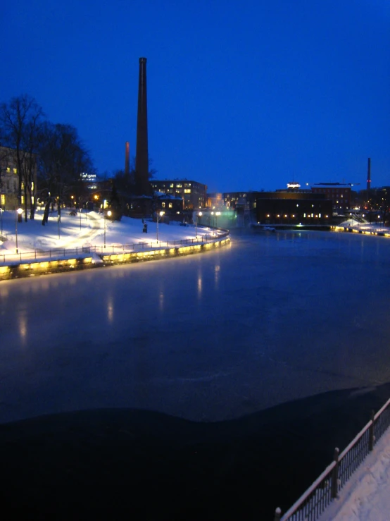 a lake is lit up at night with streetlights