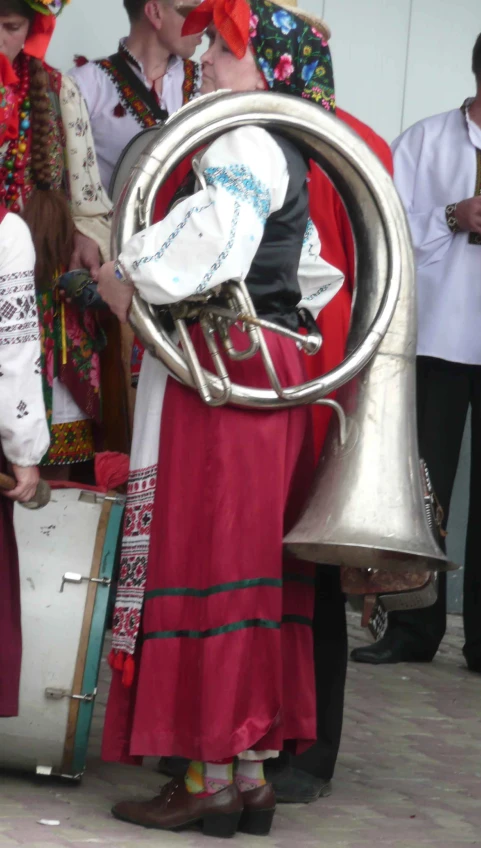 a woman is holding a metal tube and wearing a red dress