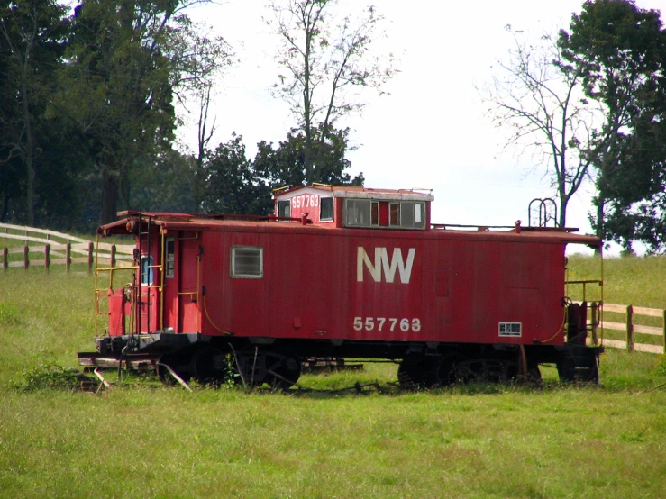 the train is parked in a grassy field