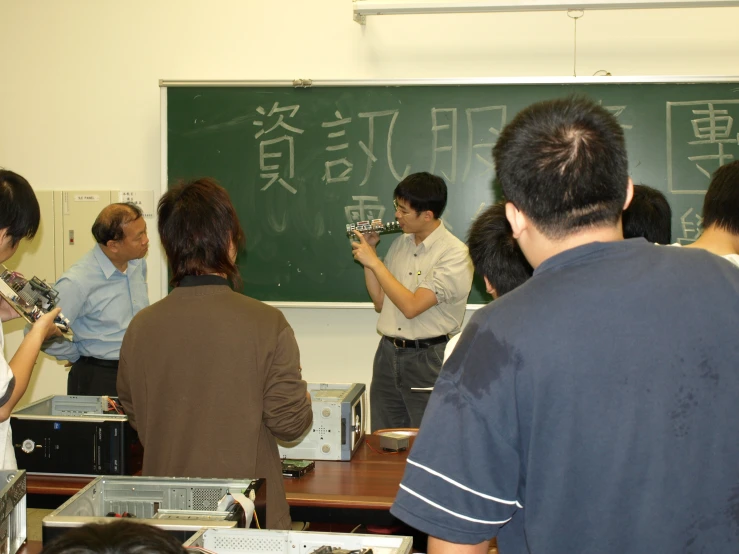 a group of people that are looking at the back of a blackboard