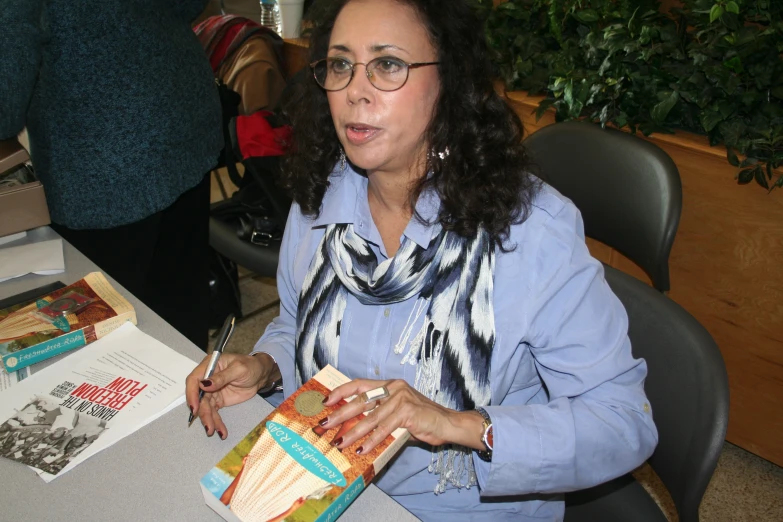 a woman wearing glasses holds up an open boxed box