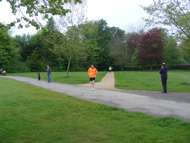 a person running down a sidewalk while people watch