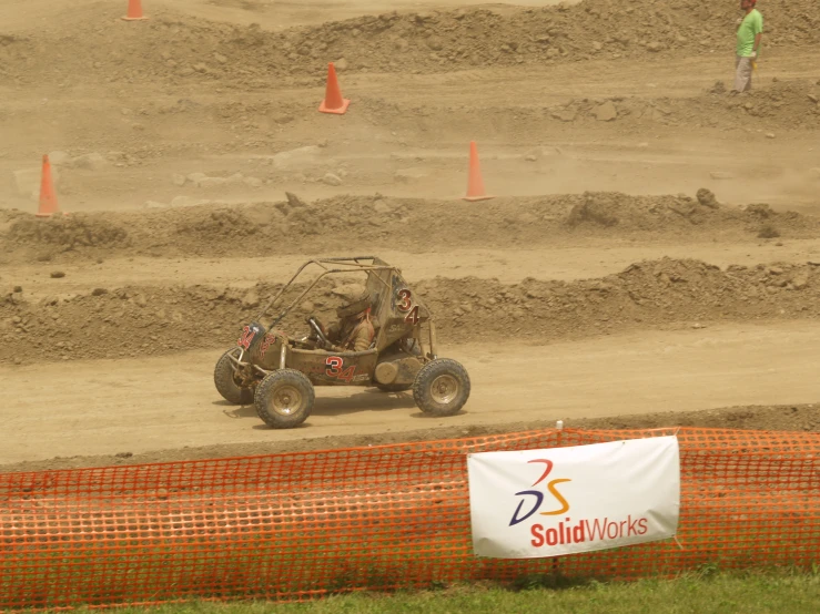 a person is driving a buggy around some mud tracks