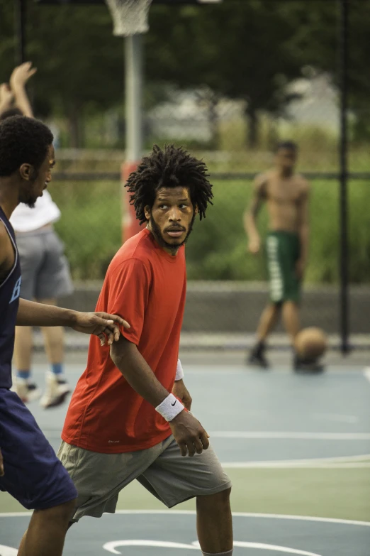 a couple of guys play basketball on a court