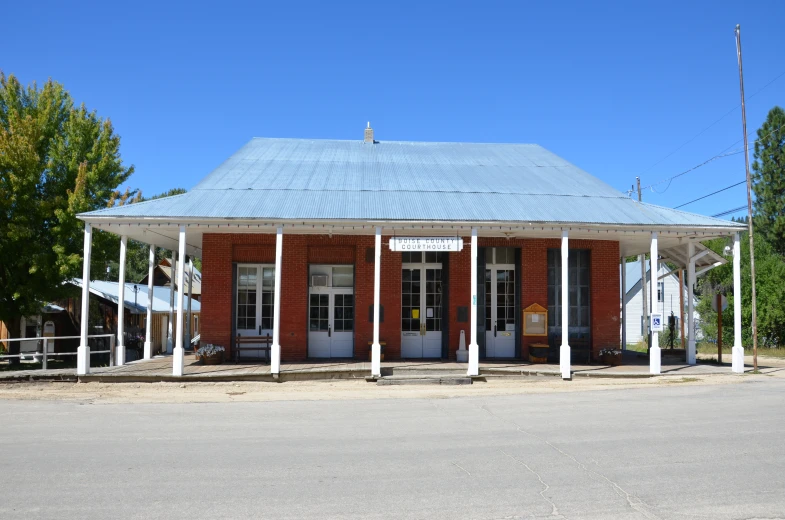 an old fashioned brick building with white pillars in front