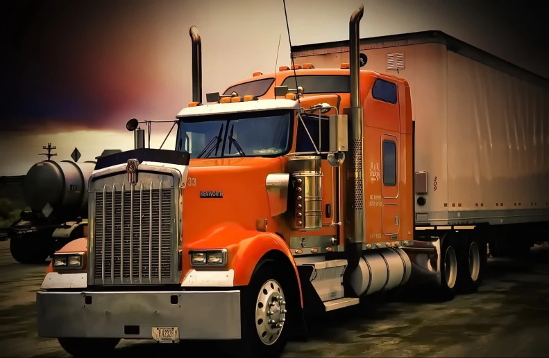 orange semi - truck cab driving on paved area