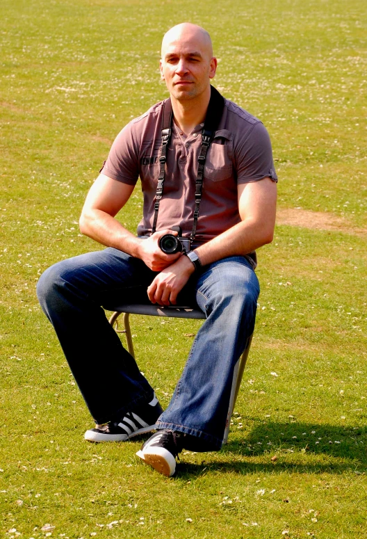 the young man is sitting on a bench taking a picture